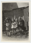 Four young girls, including two sisters in hiding, carry garlands of flowers to celebrate  the end of the war.