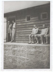 Survivors of the Gusen concentration camp rest outside the entrance to a barracks that was euphemistically called the "Banhoff."   

It was given this name because it was used as the hospital barracks where inmates were sent naked, without food until they died (railway to heaven).