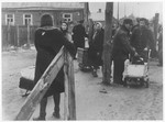 Jews are gathered near one of the entrances to the Kovno ghetto while moving their belongings into the ghetto.
