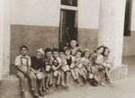 A group of Jewish DP preschool children sit outside a building in the Cremona displaced persons camp.
