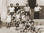 A group of Jewish DP children sit outside a building in the Cremona displaced persons camp.