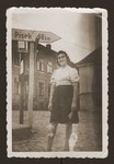 A young Jewish woman poses next to a road sign in the New Palestine displaced persons camp.