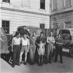 Drivers pose in front of UNRRA trucks at the Enns displaced persons camp.