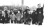A group of young school children pose with their teacher in the Novaky labor camp.