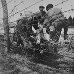 Soldiers remove corpses found in the wire of Leipzig-Thekla, a sub-camp of Buchenwald.