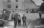 American medical personnel stand in front of a school that has been converted into a hospital for concentration camp survivors from Langenstein-Zwieberge.