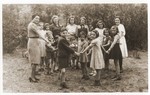 Children and teachers pose in a circle in the yard of the Lueneburg children's home.