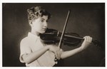 The eleven-year-old German Jewish refugee, Hellmut Stern, practices the violin in his home in Harbin, China.