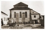 A young man draws water from a well in front of the Nieswiez synagogue.