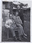 Members of the Kwar family pose outside on a lawn chair.