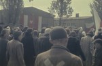 Survivors gather on the main plaza in the newly liberated Dachau concentration camp for a ceremony to salute American liberators and remember those who perished.