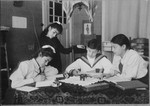 Four children gather around a table in their home.