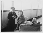 Alfred and Eva Israel sit in a chair and baby carriage on the deck of the Usambara while en route to America from Germany.