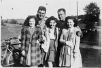 Hena Kohn and two other Jewish girls who had been in hiding pose with American soldiers after the liberation.