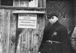 A Jewish man standing at an entrance to a workshop in the ghetto.