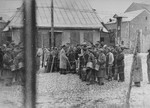 A group of Jews return to the ghetto after forced labor on the outside.