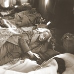 A elderly Jewish man rescued from Theresienstadt rests on a bed of straw in the Hadwigschulhaus in St.