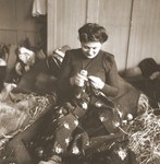 A Jewish woman rescued from Theresienstadt mends her clothing in the Hadwigschulhaus in St.