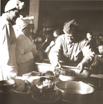 Swiss Red Cross workers and military reservists prepare a meal for Jews rescued from Theresienstadt.