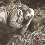 A elderly Jewish man rescued from Theresienstadt rests on a bed of straw in the Hadwigschulhaus in St.