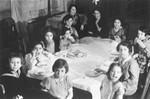 Children seated around a table at a birthday party for Eva Anker at her home on Klopstockstrasse 17 in Berlin.