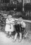 Liese and Siegbert Einstein playing toy instruments in the backyard of their home in Augsburg, Germany.