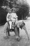 Herbert Anker (b. 1912) rides on a toy elephant with his cousin, Marianne Anker (b.