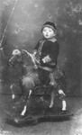 Studio portrait of Abraham Moshe Muhlbaum on a rocking horse.