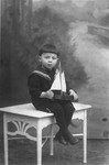 Studio portrait of Abraham Moshe Muhlbaum holding a toy boat.
