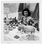 A young woman sits among a crafts exhibit in an OSE home, probably Draveil.