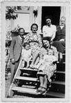 Rosemarie Schink sits on the steps to a house with a group of people including two of the Jews she hid in her attic, Lola and Lila.