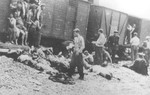 Local Roma, supervised by a Romanian policeman, help remove corpses from the Iasi-Calarasi death train during a stop in Targu-Frumos.