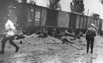 Romanian police walk past the bodies of Jews removed from the Iasi-Calarasi death train in Targu-Frumos.