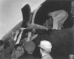 A Jewish DP who is being evacuated to Frankfurt am Main during the Berlin Blockade, is lifted on a stretcher and placed in an airplane.