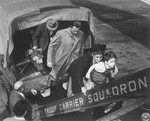 Jewish DPs who are being evacuated to Frankfurt am Main during the Berlin Blockade, walk off the back of a  truck and onto the steps of an airplane.