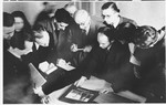 Court reporters examine a piece of evidence at the Sachsenhausen concentration camp war crimes trial in Berlin.