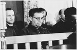 Defendants Martin Knittler (left) and Kurt Eccarius (center front) sit in the dock at the Sachsenhausen concentration camp war crimes trial in Berlin.