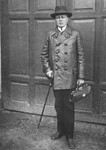 Portrait of Dr. Adolf Huber holding a cane and his doctor's bag.