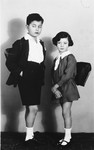 Studio portrait of two Jewish siblings wearing their school backpacks.