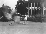 The last of the 3000 runners that carried the Olympic torch from Olympia, Greece, lights the Olympic Flame in the Lustgarten in Berlin to start the 11th Summer Olympic Games.