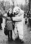 Lea Rein poses with a bear mascot in a park in Krakow after the war.