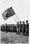 Members of the 522nd Field Artillery Battalion in Germany stand in formation with the American and battalion flags.
