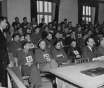 Defendants former SS General Fritz Kraemer (#33), former SS General Hermann Priess (#45), and former SS Colonel Peiper (third from the left in the first row) listen to Colonel William Everett give the defense's closing statement at the trial of 74 SS men charged with perpetrating the Malmedy atrocity.