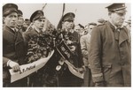 DP police from the Lechfeld displaced persons camp carry a wreath to the site of a memorial to Jewish victims at the Dachau concentration camp.