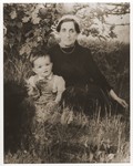 Dina Kassel Trzcina sits in the grass with her grandson, Benjamin, at the Vilseck displaced persons camp.