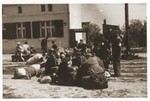 Jewish police guard a group of central European Jews who have been assembled for deportation in the central prison of the  Lodz ghetto.