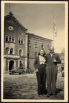 A husband and wife who survived Theresienstadt pose outside the main building of the Deggendorf displaced persons' camp.