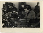 Women sew cloth slippers in one of the workshops in the Lodz ghetto.