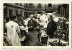 Workers in the Lodz ghetto organize a pile of abandoned personal belongings, perhaps after a deportation.