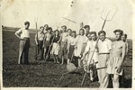 Group portrait of Jewish youth holding farming tools in a kibbutz hachshara in Germany.